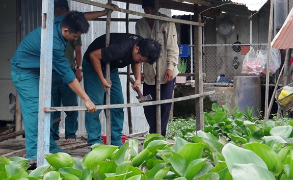 Dân quân thị trấn Sa Rài (Tân Hồng, Đồng Tháp) giúp đồng đội sửa nhà, làm vườn.